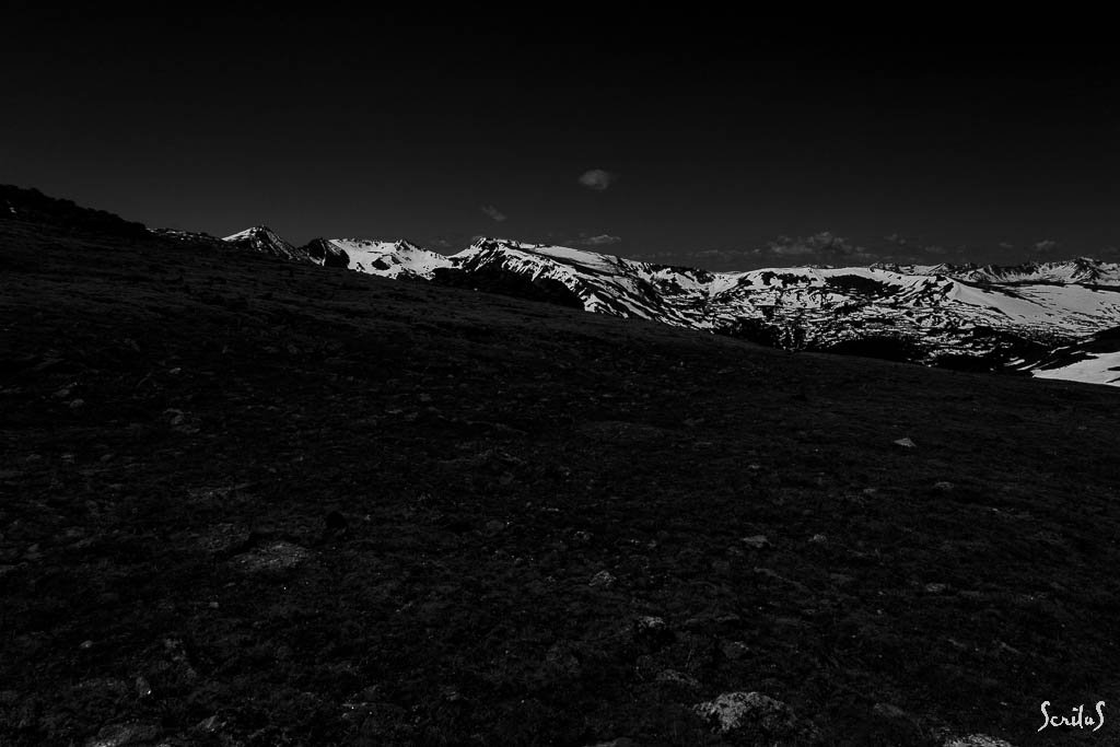 Toundra et Montagnes rocheuses sous un ciel noir.