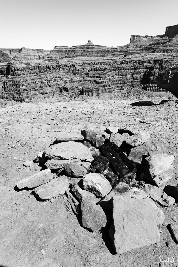 Reste d'un feu de camp sur les bords du fleuve, face aux falaises